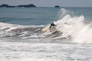 Surfer in the waves of Playa Jaco. Located on the central Pacific coast of Costa Rica, in relatively close proximity to the airport and San Jose..